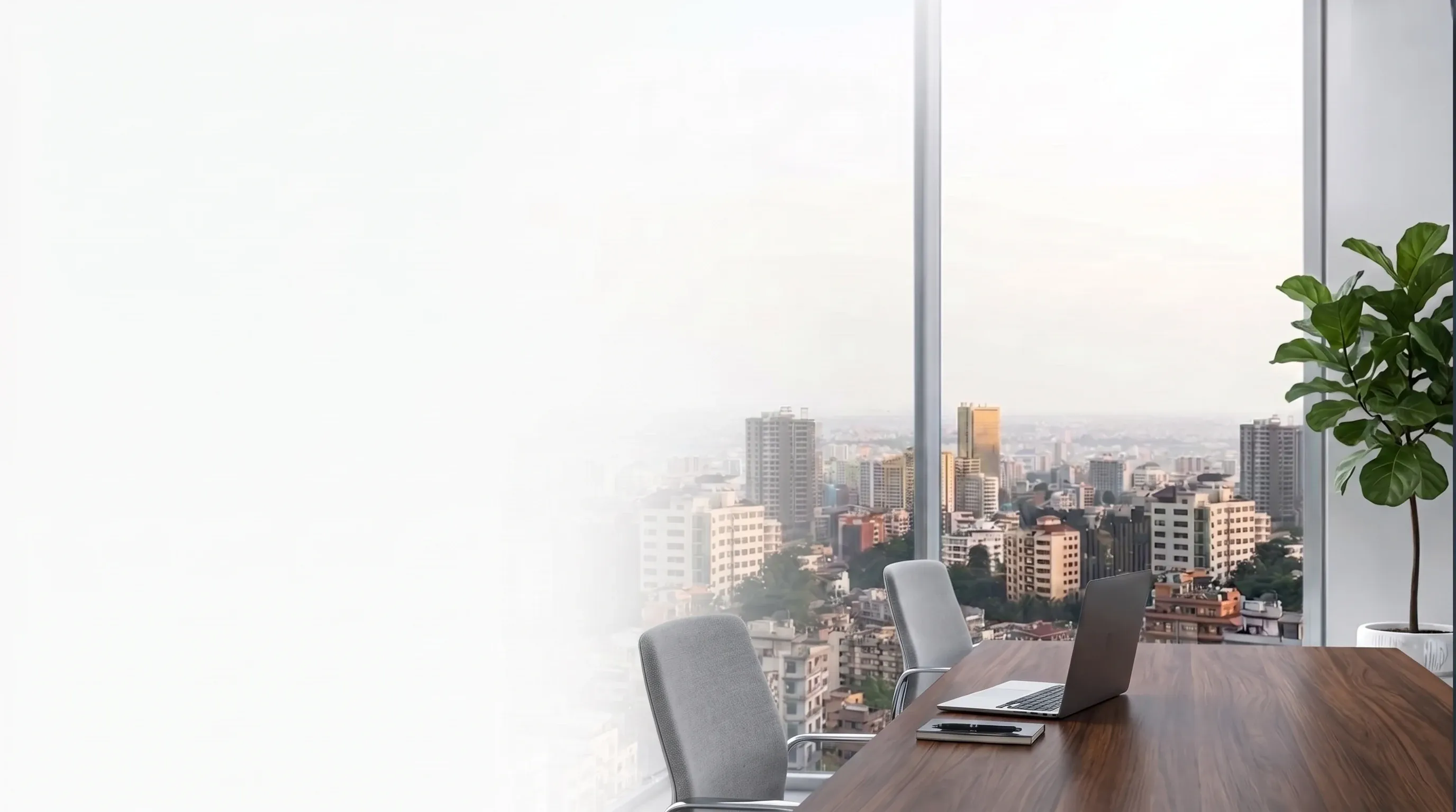 A bright meeting room with a laptop on a wooden table and a wide view over Kathmandu